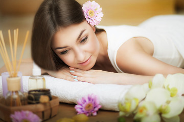 Obraz na płótnie Canvas A healthy girl relaxing on the massage table. Before the procedure in the spa. Masseur goes to massage his back. Body care. Skin care. Health and wellness