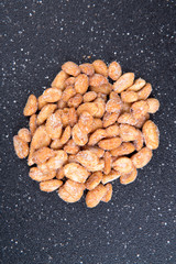 Pile of sweet roasted peanuts on a black background