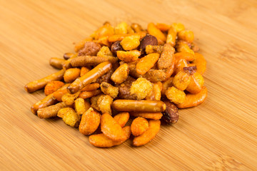 Pile of spiced crunch snack mix on a wood background