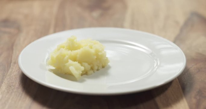 serving mashed potatoes on white plate