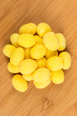 Pile of lemon candies on a wood background