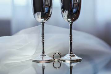 золотые обручальные кольца и свадебные аксессуары на стеклянном фоне © oes