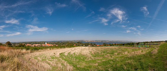 Road and field on land, near small village in background