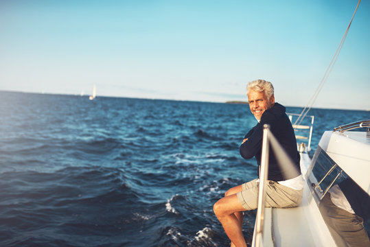 Mature man enjoying the ocean view from his sailboat