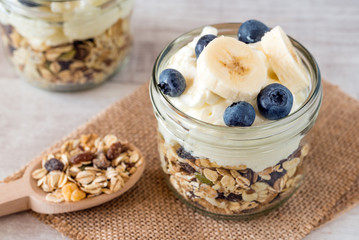 Cup of breakfast healthy muesli with blueberry, banana and yogurt.