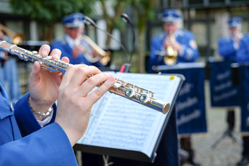 Posaunenchor in Uniform gibt Konzert  - Nahaufnahme Spieler mit Querflöte