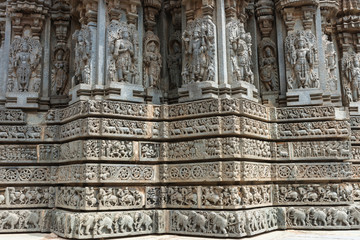 Mysore, India - October 27, 2013: Stone corner friezes with deity statues on outside wall of central shrine, called Trikuta, at Chennakesave temple in Somanathpur. 