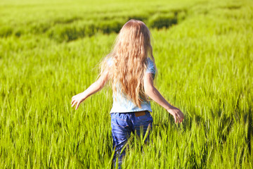 Fototapeta premium Happy little girl in green field