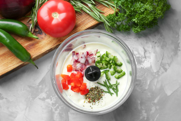 Blender bowl with ingredients for fish taco sauce on table