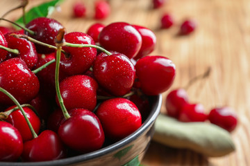Bowl with tasty ripe cherries on table, closeup