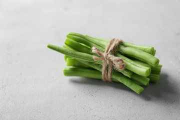 Bunch of fresh green beans on light background