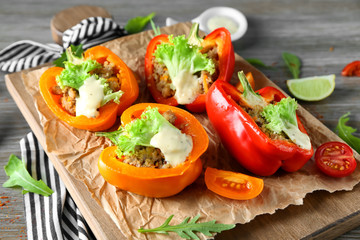 Quinoa stuffed peppers served with vegetables on wooden table