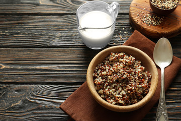 Fototapeta na wymiar Bowl with boiled quinoa grains on wooden table