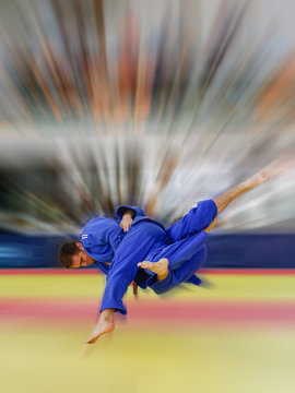 Judoka in blue judogi throwing his opponent for ippon with amazing Uchi Mata
