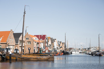 Fototapeta na wymiar Sail boats and motor boats docked in a harbor in the historic fishing village of Urk in the Netherlands