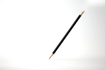 Black color pencil levitation isolated on white background with light and shadow.