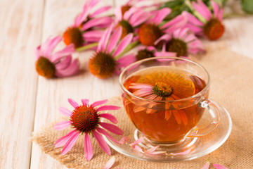 Cup of echinacea tea on white wooden table
