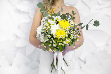 wedding yellow bouquet in bride's hands white background
