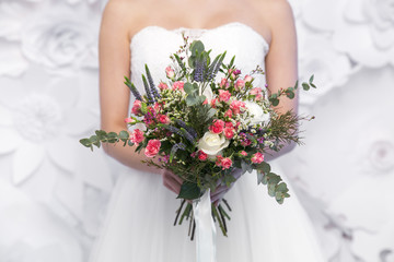 Obraz na płótnie Canvas wedding colourful bouquet in bride's hands white background
