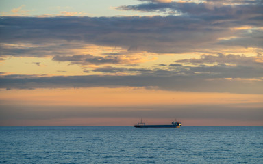 Naklejka na ściany i meble Ship and Cloudy Sky at Sunset Over The Sea
