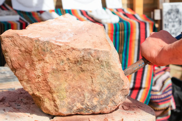 Artisan stonecutter with ancient tools of an ancient artisan stonecutter in Discovery Medieval Fair in a town called Palos de la Frontera