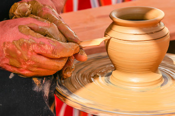 Hands of potter man making a jar