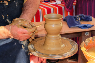 Hands of potter man making a jar