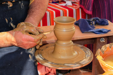 Hands of potter man making a jar