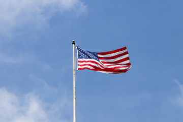 United States of America flag with cloudy blue sky