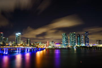 Obraz premium Miami city skyline panorama at dusk with urban skyscrapers and bridge over sea with reflection