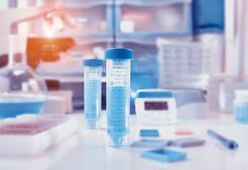 Scientific background with closeup on plastic tube and lab space out of focus