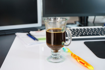 Black dark espresso coffee and toothbrush on table