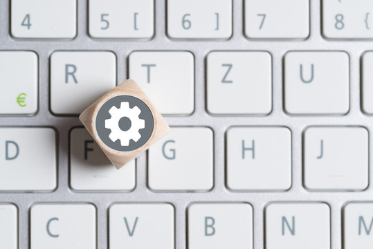 W&uuml;rfel auf Tastatur mit Getriebesymbol