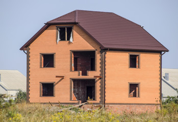 The house with plastic windows and a roof of corrugated sheet
