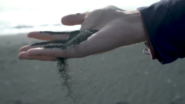 Hands with black sand at the iceland Beach.