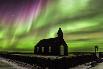 Magic light above the black wooden church of Budoir, Iceland