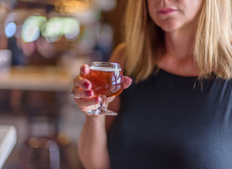 woman holding glass of beer at microbrewery