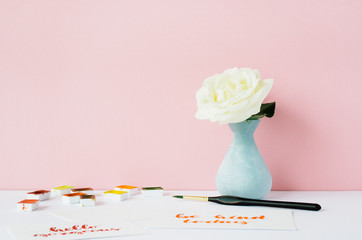 Artist workspace in front of pale pastel pink background. Blog, website or social media concept