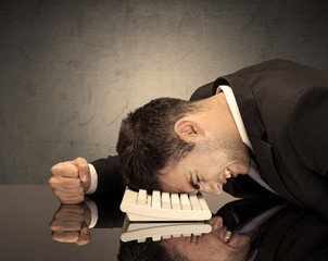 Obraz premium Frustrated businessman's head on keyboard