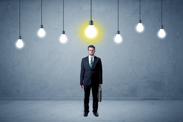 Obraz premium Businessman standing uninspired with bulbs above