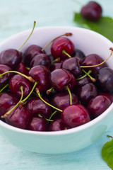 cherries on a turquoise wooden surface
