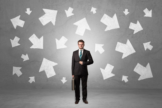 Businessman standing with arrows around