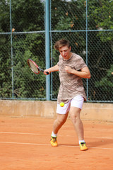 Teenage boy try to play forehand on the tennis court