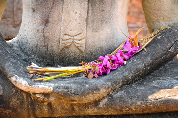 Pray on old Buddha statue by flower