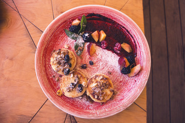 Syrniki - cottage cheese pancake cheesecake with nuts, raspberry, blackberry, raisins and peach