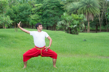 Asian young boy Thai dance. Classical Dance in white shirt red loincloth, Demonstrate dance in the garden.