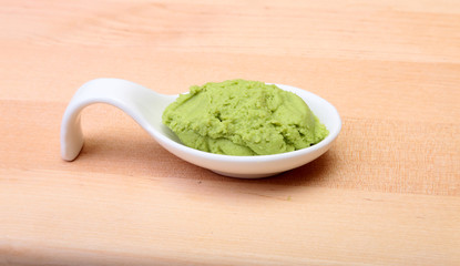 plate with Japanese wasabi sauce on wood background.