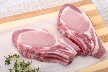 Raw pork chops, spices and rosemary on cutting board. Ready for cooking.