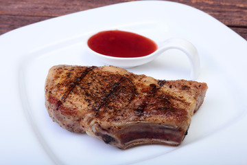 grilled pork chop with Cranberry sauce on plate on wooden board
