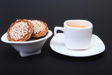 Classic espresso in white cup with homemade cake on black background. Selective focus.